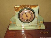 Front view of the Sessions alabaster Deco style clock showing its geometric design and brass-rimmed face.