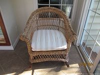 Wicker rocking chair with a padded striped cushion on seat