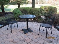 Full set outdoors on patio showing table and two chairs