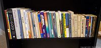 Shelf with 22 religion-themed books arranged side by side, varied colors and sizes, including visible titles 'With or Without God,' 'Paul the Convert,' 'The Mythmaker,' and others.