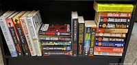 Photo of bookshelf with a wider view showing various novels by Jeffrey Archer, James Patterson, Patricia Cornwell and others, multiple titles visible