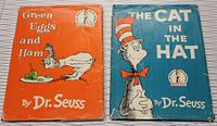 Front covers of two hardcover Dr. Seuss books, 'Green Eggs and Ham' and 'The Cat in the Hat' showing colorful illustrated original dust jackets with signs of wear.