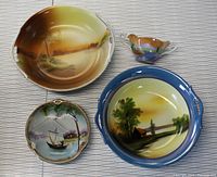 Four hand painted Noritake china pieces showing different scenic landscape and floral themes