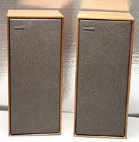 Pair of Celestion Ditton 15 speakers with front grilles on, showing carpet-like black mesh and Celestion badges.