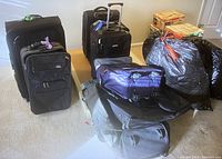 Photo of nine black luggage bags, assorted sizes.