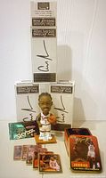 Front view of three Allen Iverson bobbleheads in boxes, a mystery pack of Skybox basketball cards, loose basketball cards, and a tin box of Michael Jordan collector cards.