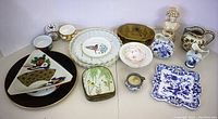 Full lot overview showing six plates, four bowls, porcelain box, vintage woman sculpture, and decorative ceramic pieces