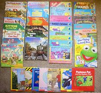 Photo showing the full collection of 37 children's paperback books arranged side by side on the floor. Titles are visible and colorful, featuring various themes and characters.