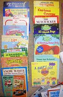 Photo showing a selection of colorful children's paperback books including titles such as The Princess and the Goblin, The Nutcracker, Curious George, Snow White, and Ninja Turtles, arranged on a carpet.