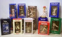 Wide group photo showing 12 of the Phillies bobbleheads in boxed packaging, including Cliff Lee, Charlie Manuel, Carlos Ruiz, Cole Hamels, Jamie Moyer, Chase Utley, Bryce Harper, Jim Thome, and two Placido Polanco figures.