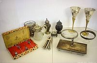 Wide shot showing all items in collection with chalices, salt and pepper shakers, nutcrackers, dishes, coasters, and condiment dishes.