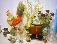 Photo of all home decor items including handcrafted chicken, fake flowers, vintage binoculars, glass jars, ceramic items, and decorative bowls arranged on white surface