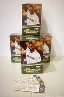 Four boxes of 2009 Ken Griffey Jr. bobblehead collectibles stacked with several original game tickets placed in front.