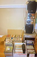 View of Philips stereo system with speakers and boxes of CDs placed beside and in front