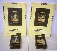 Two Pinnacle collectible tins and two corresponding vintage score film pictures featuring Joe DiMaggio of the New York Yankees displayed side by side showing front designs and print test marks