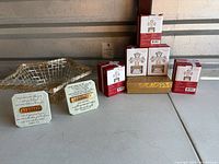 Full lot showing five boxed Mikasa crystal candle holders, two word art pieces, and gold wire basket