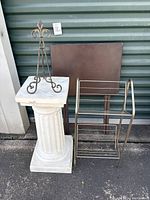 Photo showing a white decorative pedestal column, a metal wire display stand, and a vintage metal TV tray with brown top.