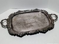 Top view of silver-plate tray showing ornate border and handles