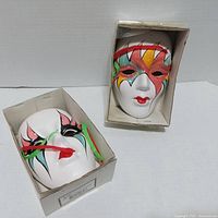 Two white bisque porcelain wall masks in boxes