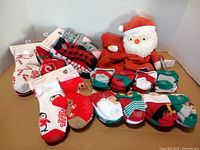Group of children’s Christmas socks and Santa plush arranged on tabletop