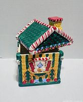 Front view of ceramic gingerbread house cookie jar with lid in place