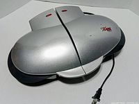 Closed GT Xpress 101 Deluxe Turbo Cooker Plus showing silver exterior and power cord