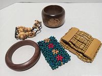 Top view of five wooden bracelets displaying shapes, colors and bead styles