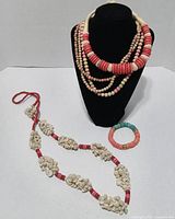 Group of four wood bead necklaces, one shell and wood bead necklace, and one wood bead bracelet