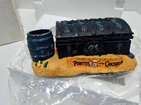 Resin Post-It holder depicting treasure chest and barrel on sand with Pirates of the Caribbean logo