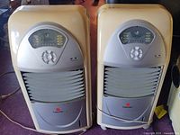 Two Fujitronic portable air coolers standing side by side showing full fronts, control panels, louvers, wheels and power cords.