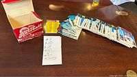 Photo showing an open 1986 Topps Baseball card box, a pile of individual cards ordered roughly in numeric sequence and a note listing missing card numbers.