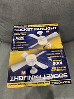 Two boxed Bell & Howell Socket Fanlight units stacked, showing the front of packaging with product features.