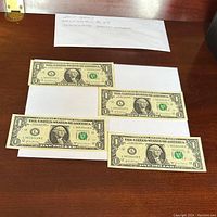 Four 2017 U.S. one dollar bills showing front with serial numbers in sequence: L36590106E, L36590107E, L36590108E, L36590109E.