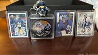 Front view of hockey cards, collectible puck, and hockey player keychain showing Curtis Joseph and Toronto Maple Leafs branding.