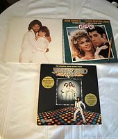 Photo showing front covers of the three vinyl records: Saturday Night Fever, Grease soundtrack, and Guilty album.