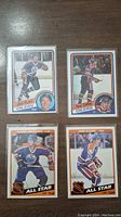 Front view of 4 Edmonton Oilers hockey cards from 1984, featuring Jari Kurri, Paul Coffey, and NHL All-Star cards for Jari Kurri and Mark Messier.