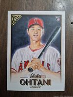 Front view of Shohei Ohtani rookie baseball card showing painted portrait and team logo.