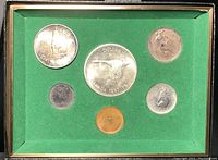Front view of six Canadian Centennial coins from 1967 in green display case.