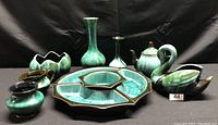 Blue Mountain pottery assortment displaying various vases, pots, bowls, teapot, and swan figurine in traditional blue-green glaze.