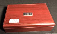 Sealed polished wood box with metal plaque labeled '2008' showing the exterior of the collection case.
