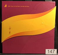 Closed presentation folder for 2003 Year of the Ram set with red cover and yellow band.