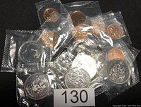 Overall view of one cent and fifty cent Canadian coins in sealed plastic packaging, assorted by date and type.