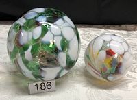 Photo showing the two hand blown glass balls, one larger green and white with mosaic pattern, and the smaller multicolor ball.