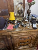 Top-down view of dresser surface with fedora, clock, watches and various accessories