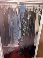 Closet view showing a row of men's clothing including jackets and shirts in various dark and neutral shades, size 42.