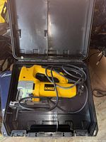 DeWalt yellow and black electric jigsaw in a plastic carrying case.
