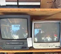 Two CRT TV/DVD combo units on shelf; one black Braytonic and one white Magnavox.