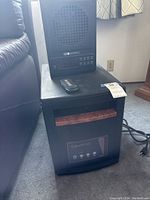 Front and top view of EdenPure heater and fan stacked, showing remote control on top of heater