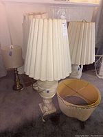 Three marble base lamps with tall cream-colored pleated shades and one brass base lamp with smaller cylindrical shade. Limited cleaning needed.
