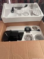 Le Presse kitchen press device components neatly packed in original styrofoam inside opened cardboard box.